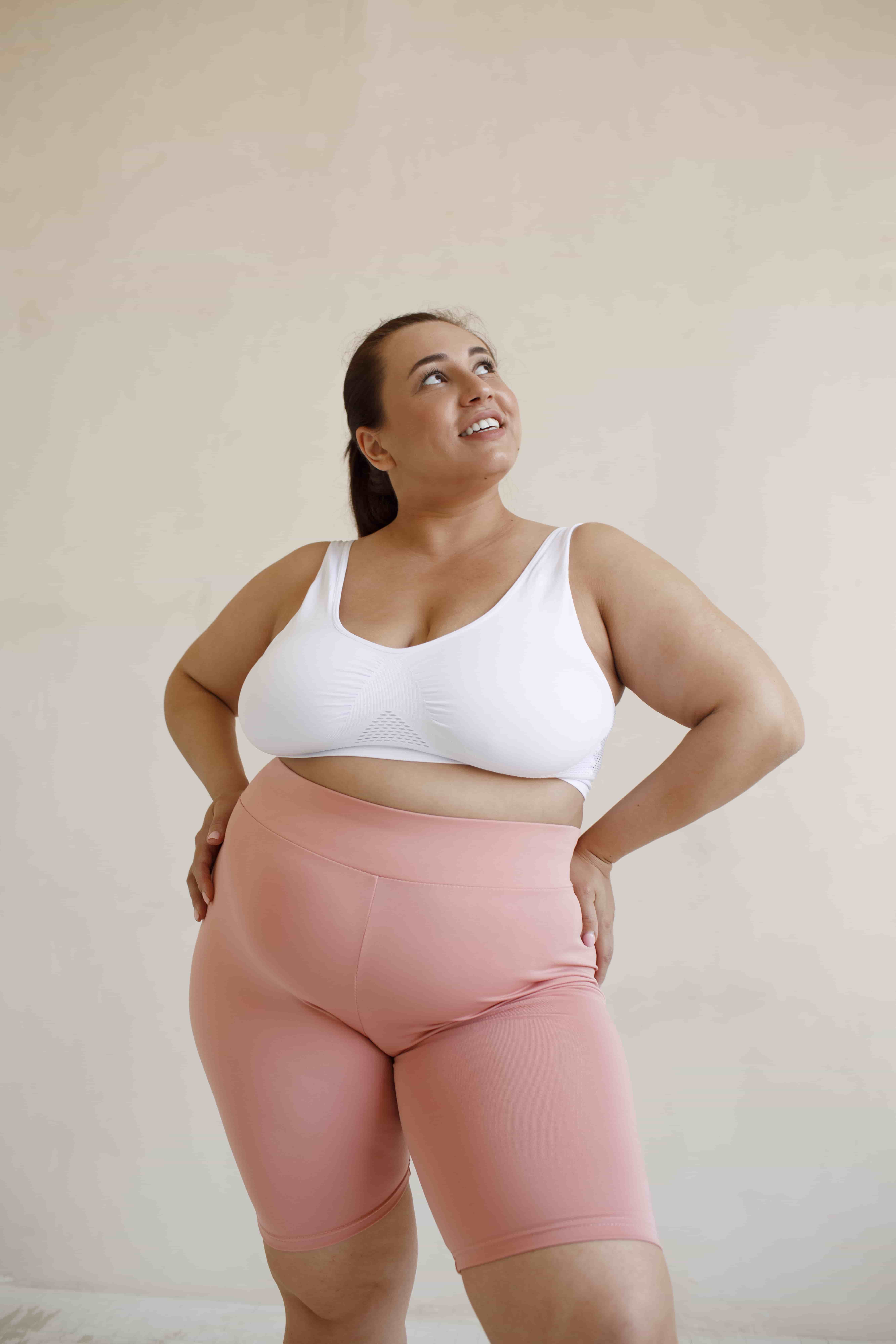 Девушка plus size в розовых лосинах