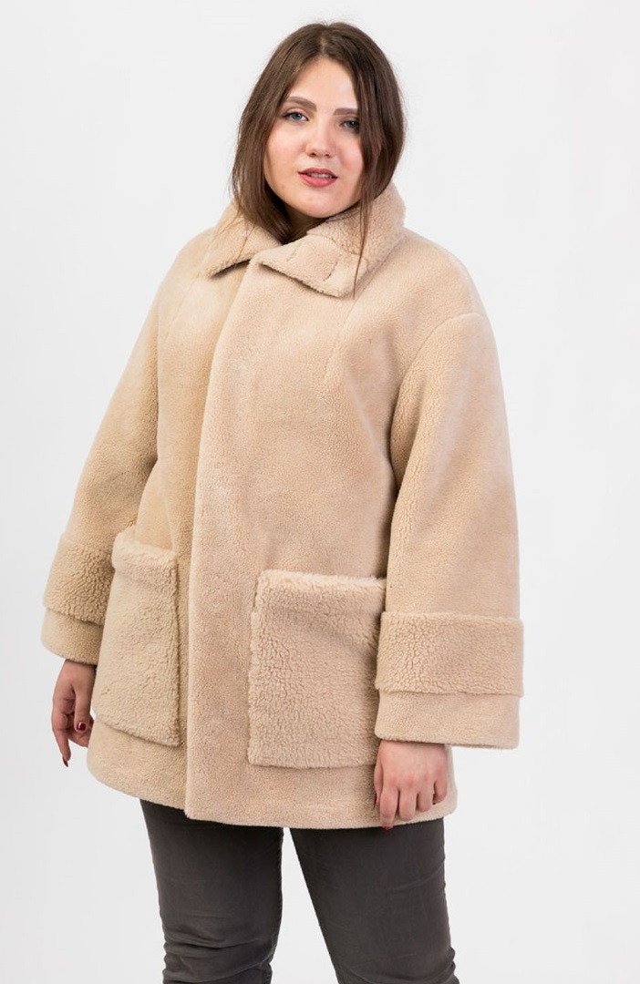 Плюс сайз девушка в теплой бежевой куртке