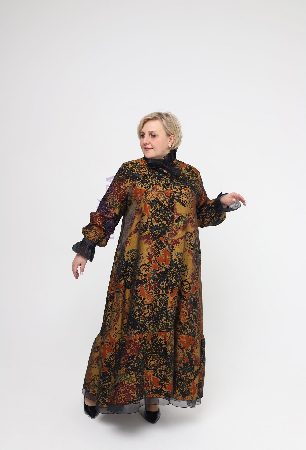 Шикарное золотистое платье с завивающимися узорами до пят с черными манжетами и бантом на воротнике